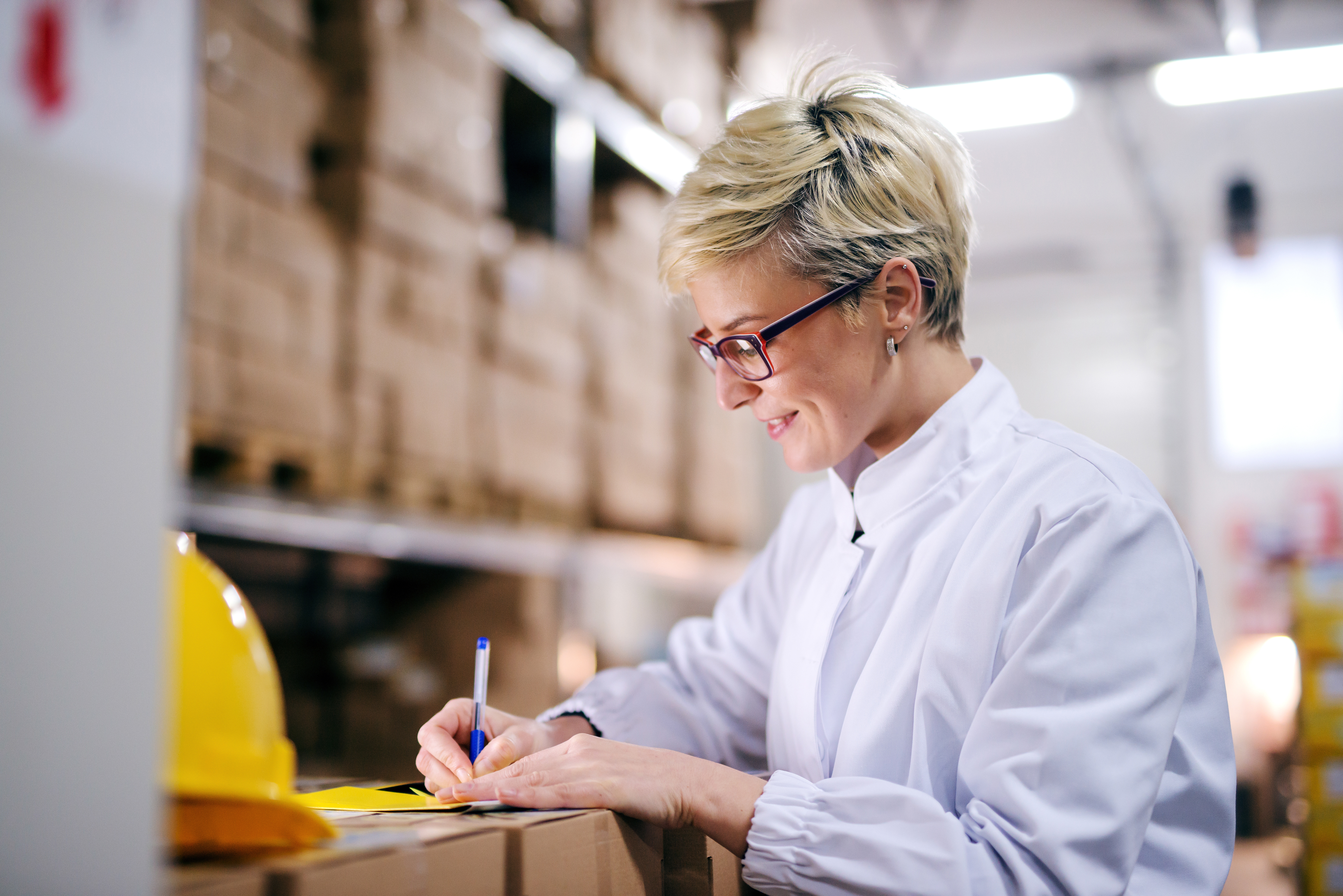 Image of a woman in a warehouse writing